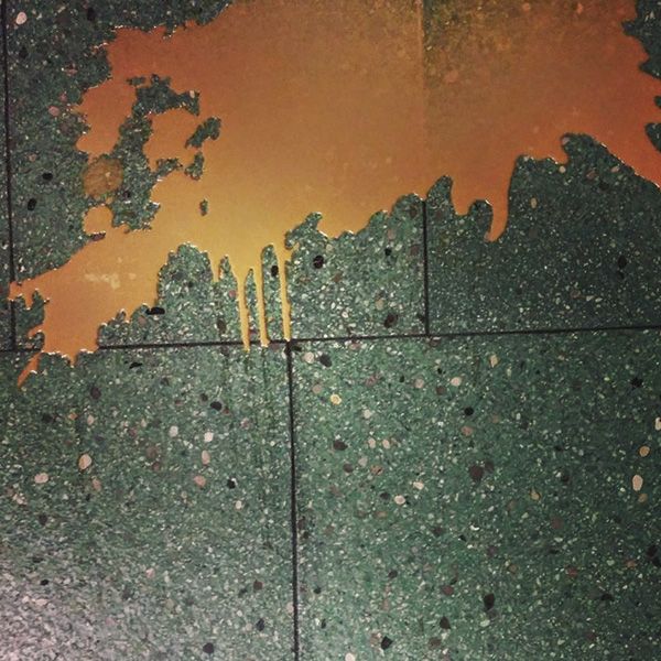Werkstattboden mit grünem Terrazzo und Lackspuren, abstrakte Detailaufnahme
