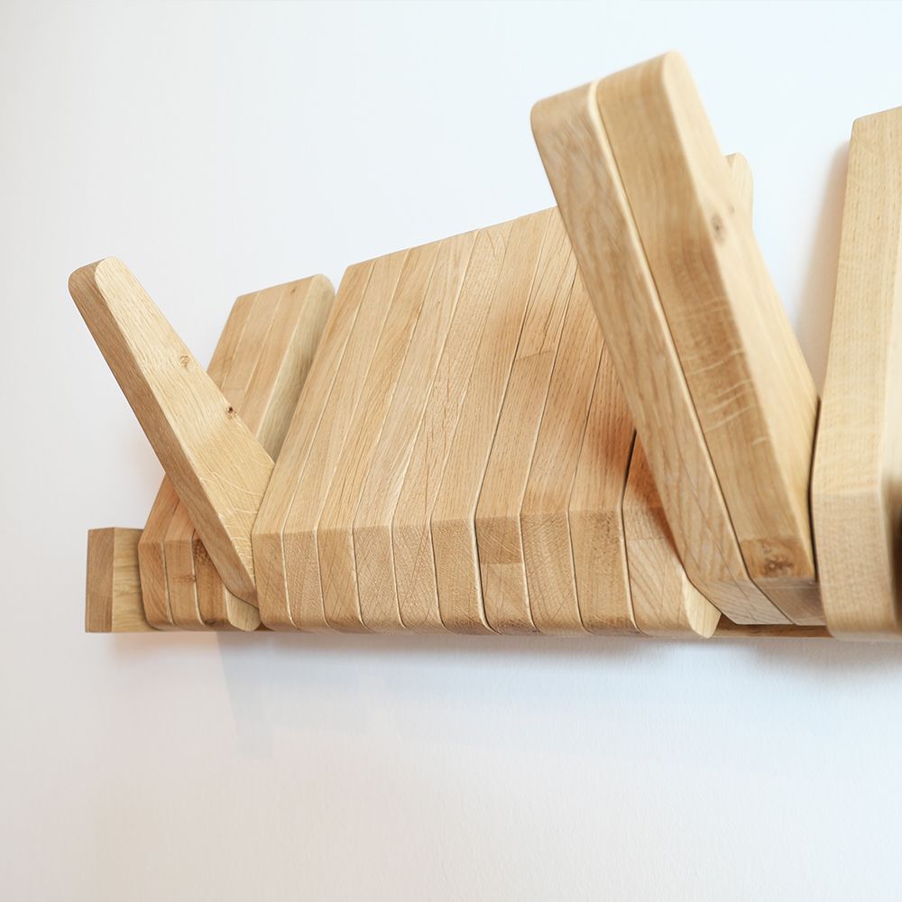 Herrendiener aus massiver Eiche mit klappbaren Holzlamellen als Haken an weißer Wand