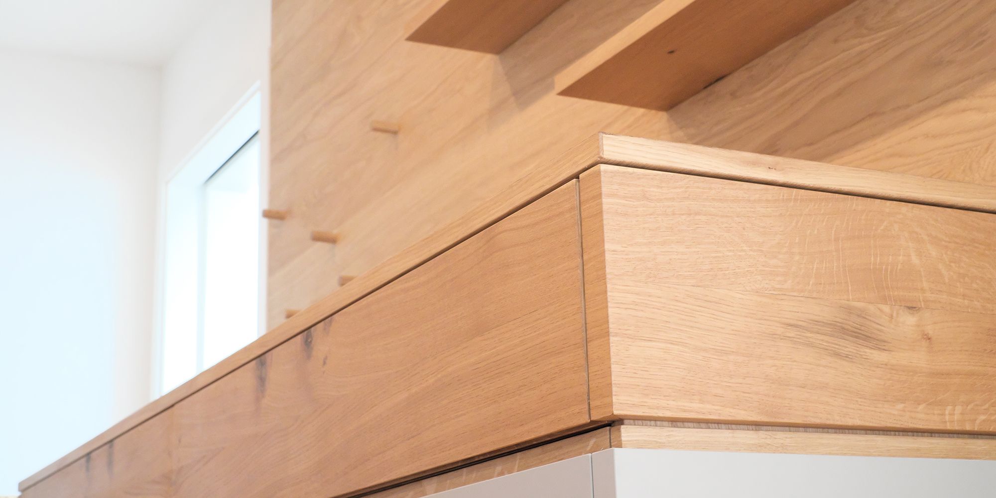 Detailansicht Sideboard aus Eiche mit sauberer Gehrung und offenen Fächern in Ankleide