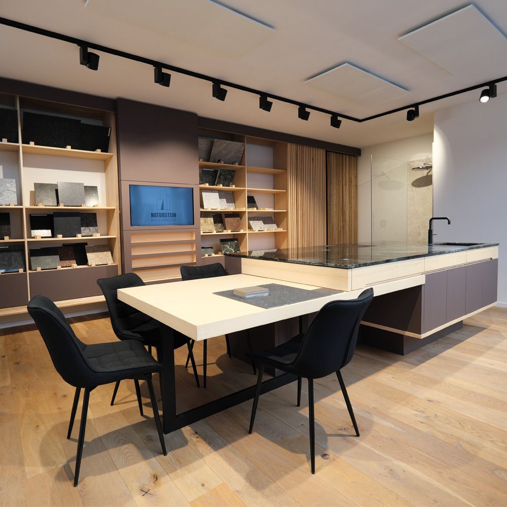 Showroom von Holzfreude mit Natursteinmustern, Besprechungstisch und Kochinsel mit Steinplatte
