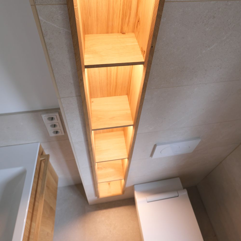 Schmales Wandregal aus Eiche mit warmer LED-Beleuchtung in gefliestem Badezimmer
