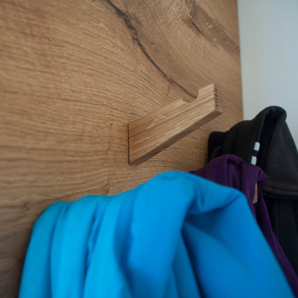 Massivholz-Kleiderhaken aus Eiche an Garderoben-Einbauschrank mit hängenden Jacken