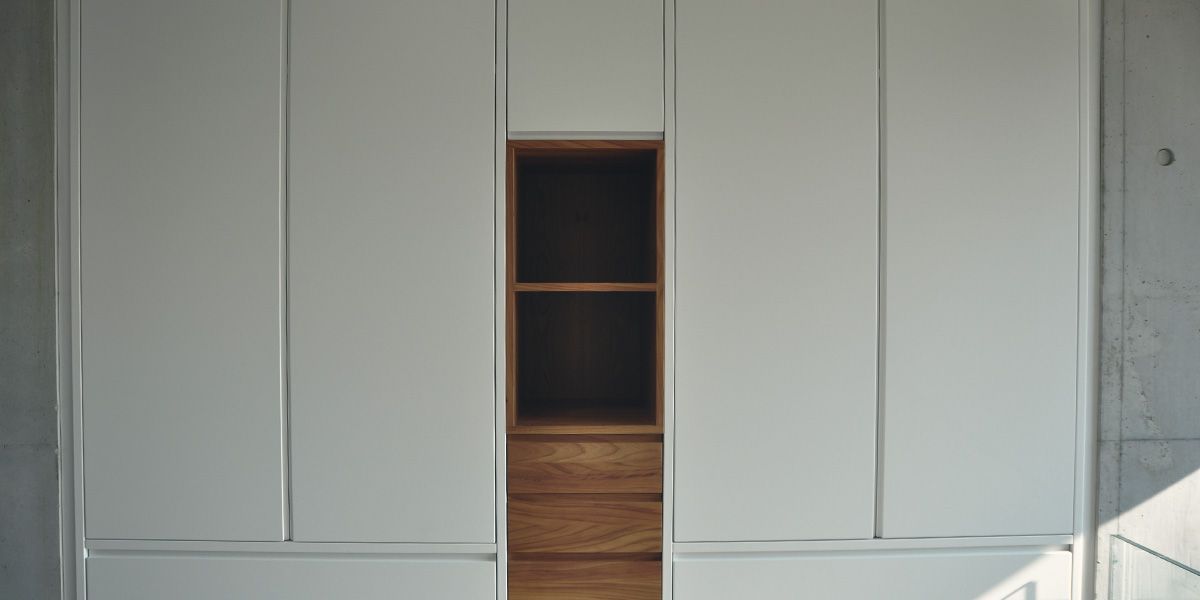 Frontalansicht Einbauschrank mit weißen Fronten und offenem Nussbaum-Regalfach mit Schubladen