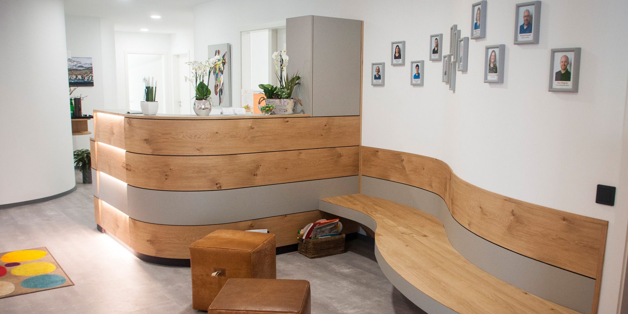 Wellenförmiger Empfangstresen aus Eiche mit angeschlossener Sitzbank und grauem Linoleum