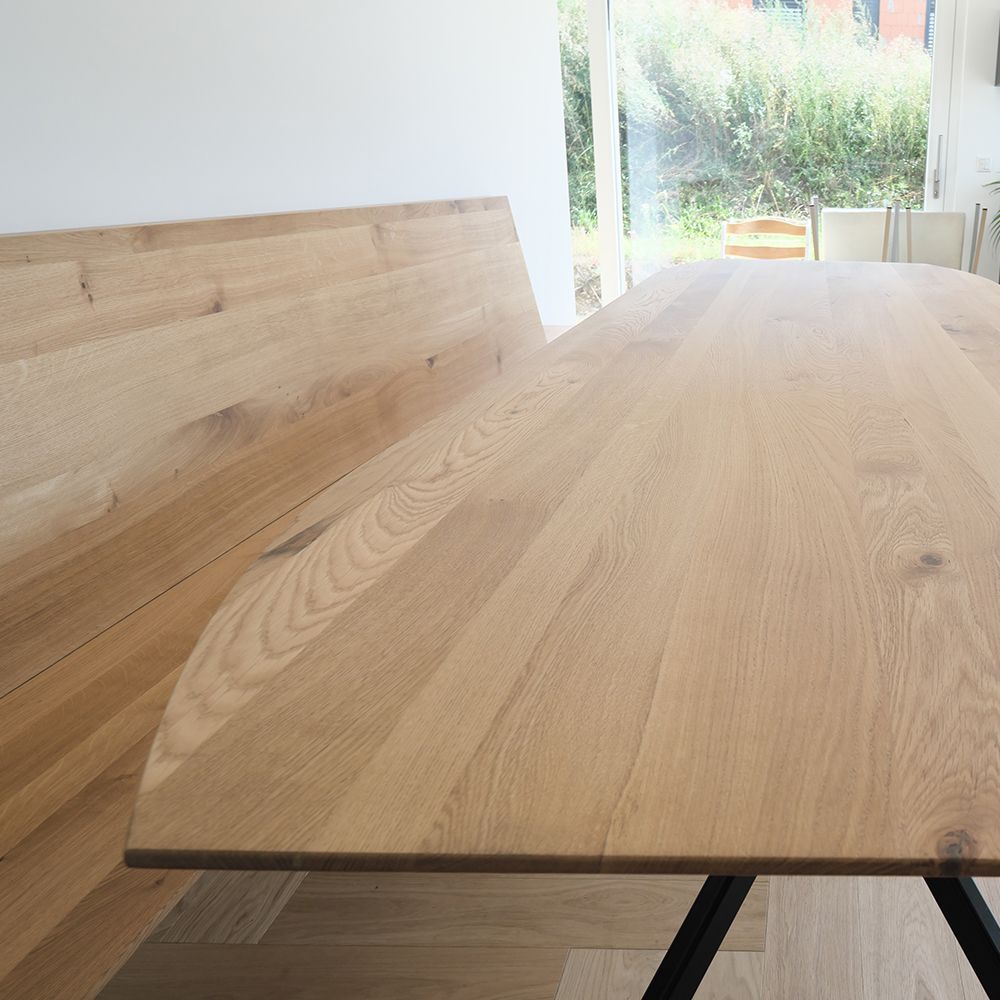 Detailaufnahme der abgerundeten Massivholz-Eichentischkante mit natürlicher Maserung und Astlöchern