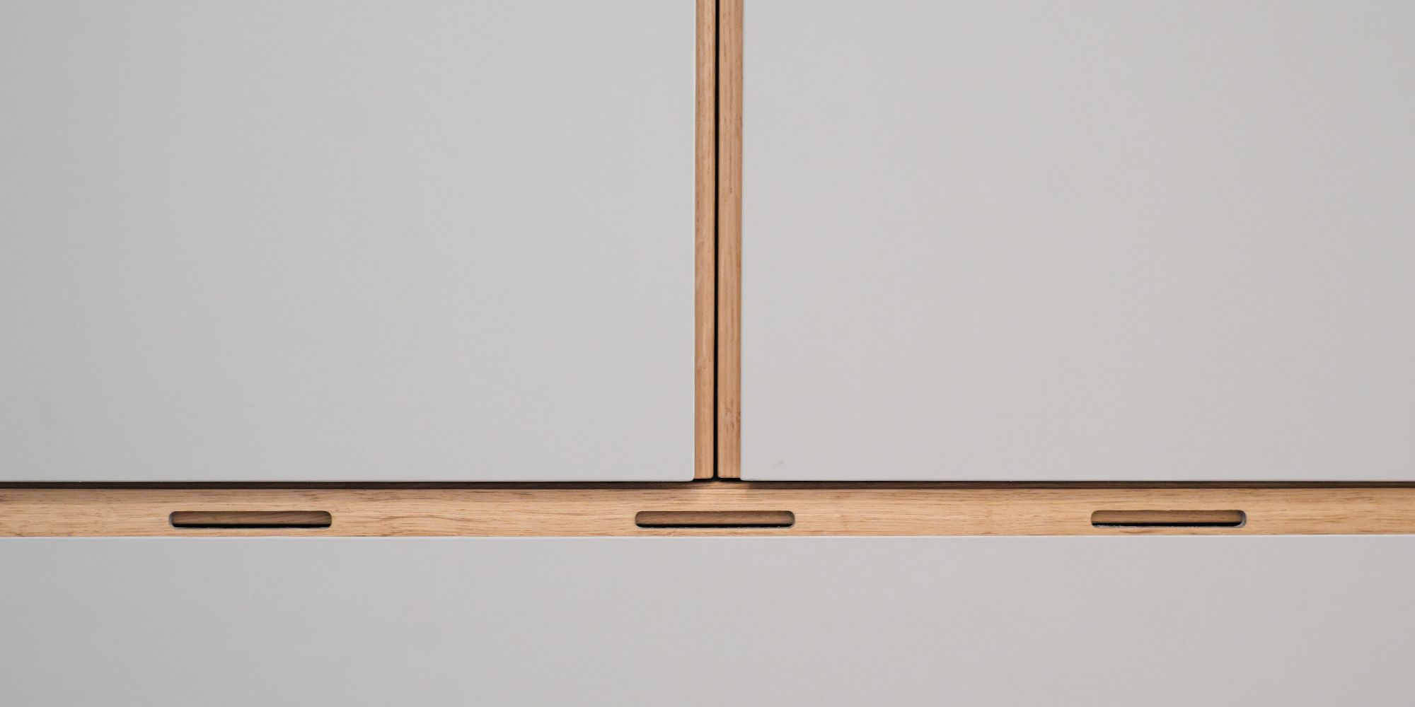 Detail einer Garderobe mit Eichen-Griffleiste und integrierten Belüftungsschlitzen am Schuhschrank