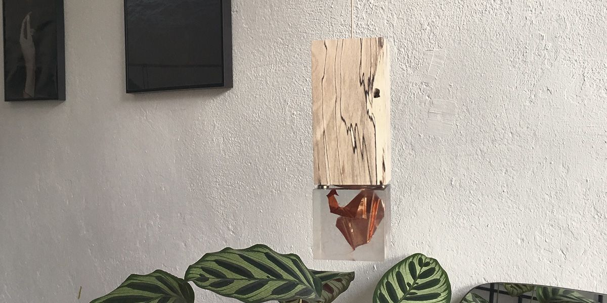 Zilpzalp-Leuchte mit auffällig gemasertem Holzkopf und Glaskörper mit Origami-Vogel-Motiv