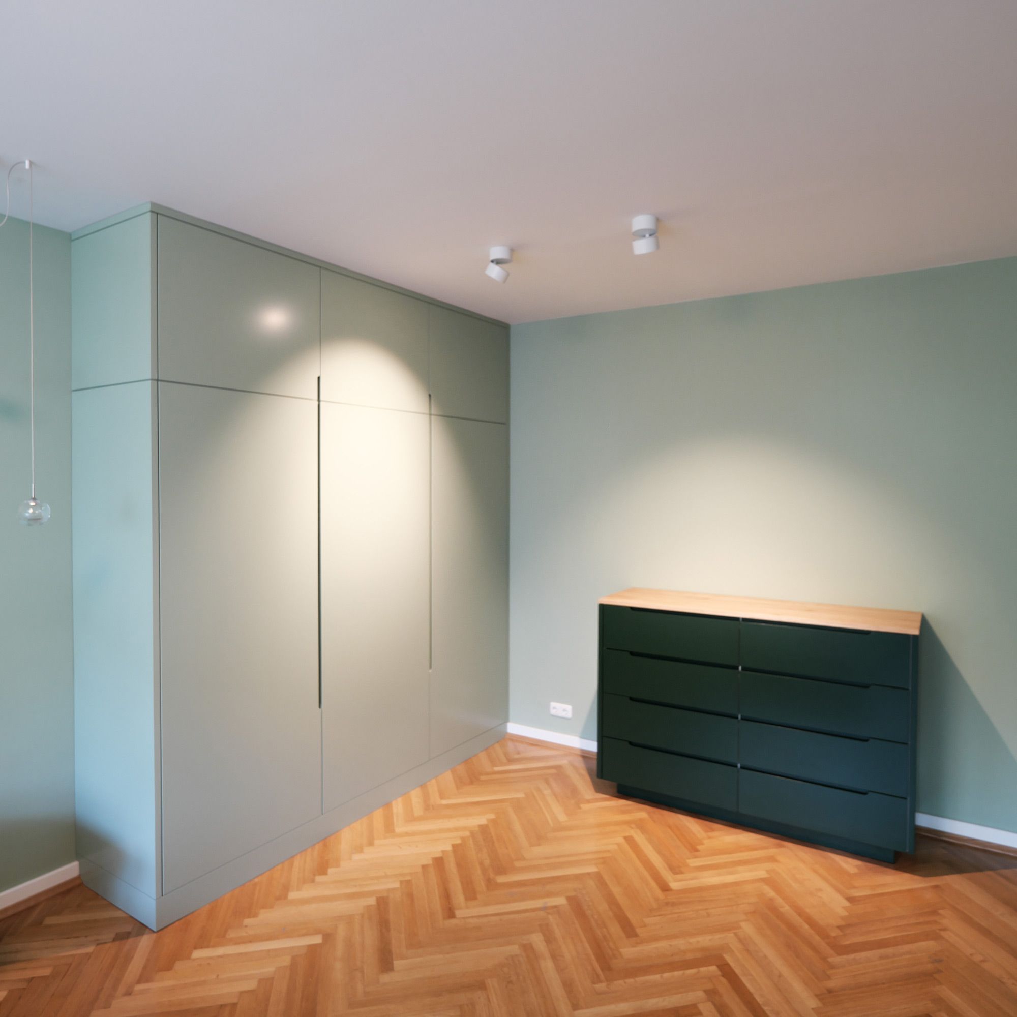 Salbeigrüner Einbauschrank mit Griffleiste und dunkelgrüne Kommode mit Eiche-Deckplatte im Schlafzimmer