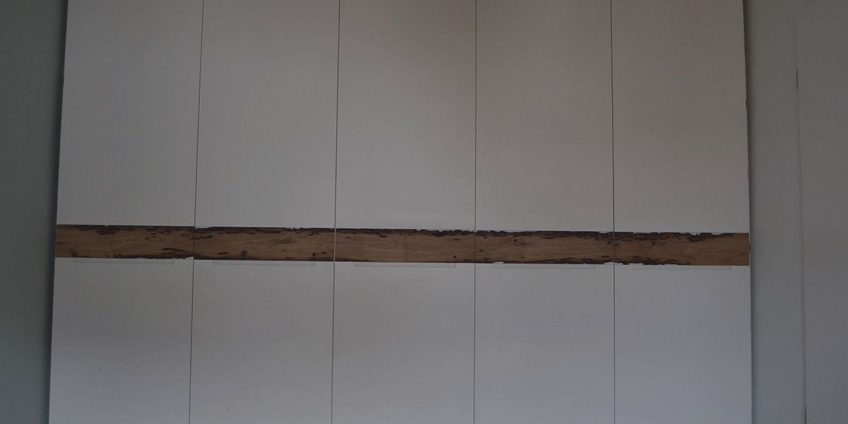 Weißlackierter Einbauschrank mit durchgehendem Band aus Bohrmuscheleiche über die gesamte Breite