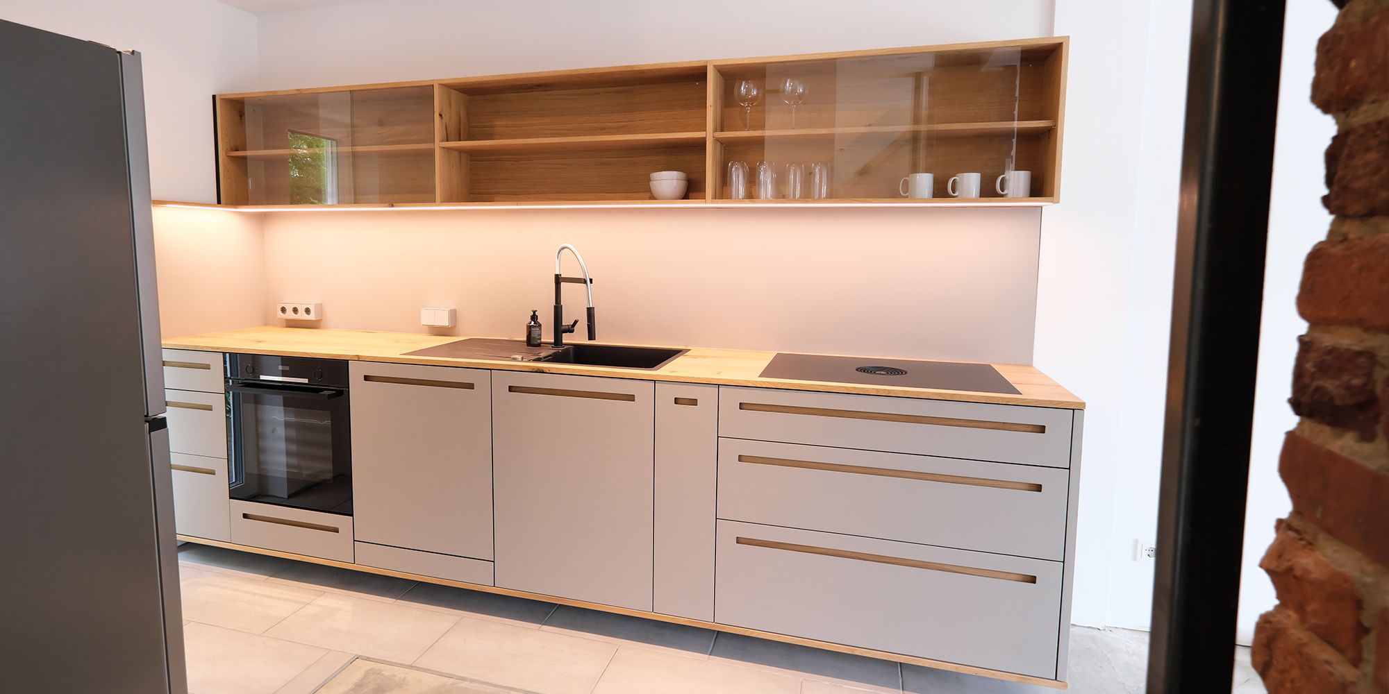Moderne Einbauküche aus Eiche mit Linoleum-Fronten, Glasvitrine und indirekter Beleuchtung