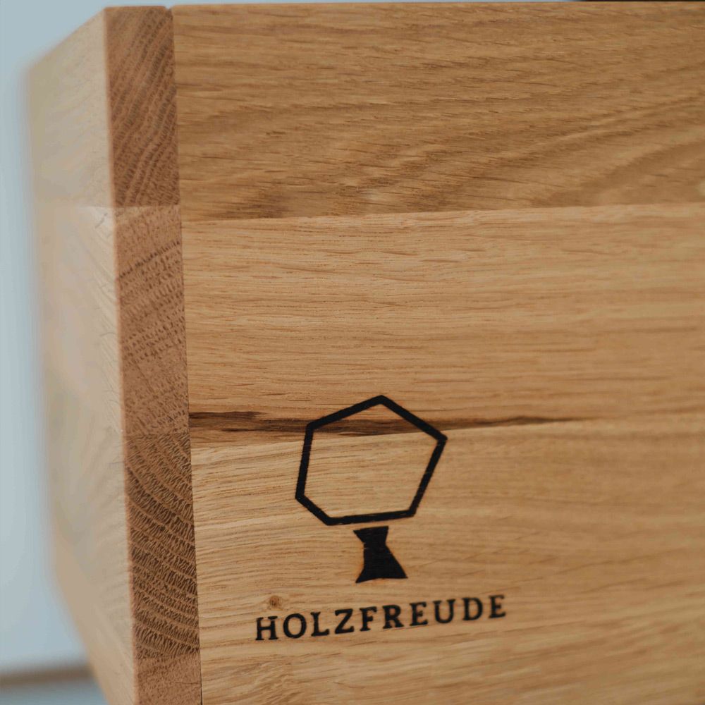 Eingebranntes Holzfreude-Logo auf massiver Eichenholzkante mit sichtbarer Maserung