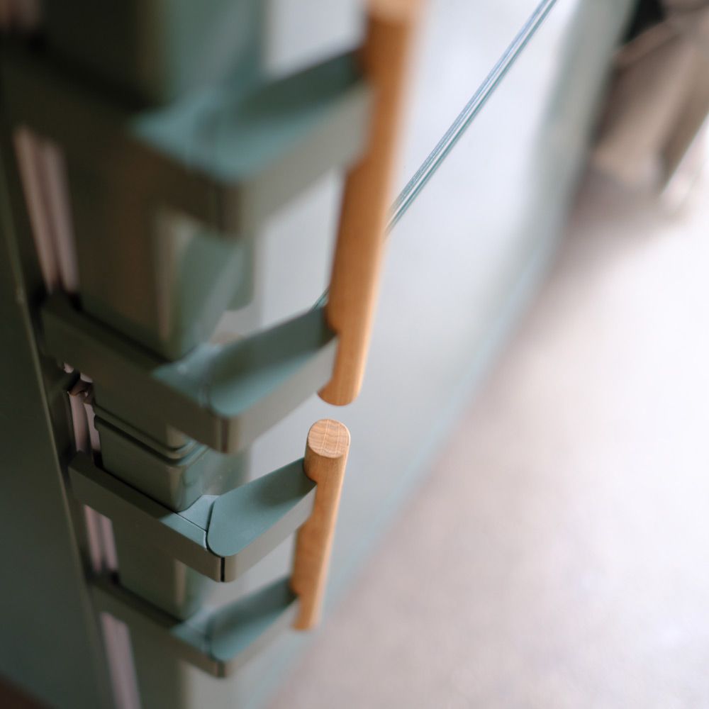 Nahaufnahme runder Eichenholzgriffe am salbeigrünen Kühlschrank-Upcycling