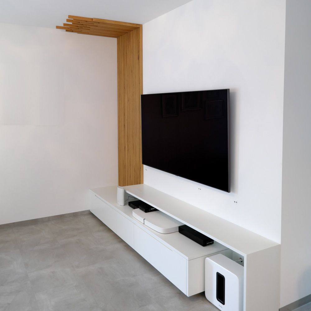 Weißes Lowboard unter TV mit dekorativer Holzlamellenwand im minimalistischen Wohnzimmer