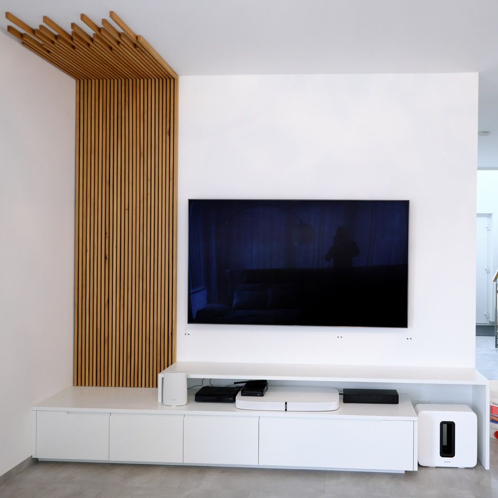 Weißes Lowboard mit geschwungener Holzlamellenwand als Designelement im Wohnzimmer