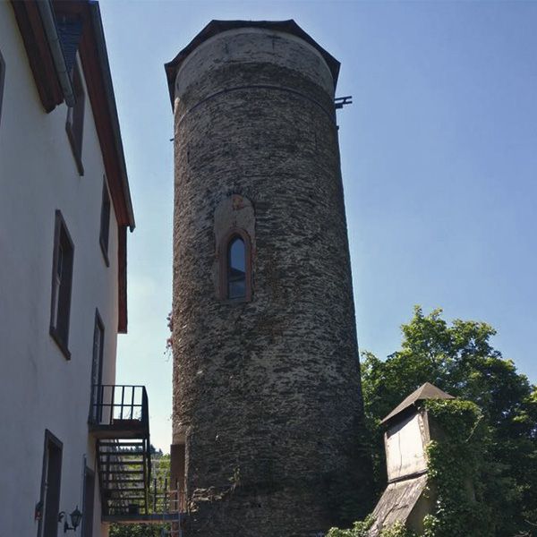 Historischer Bunkerturm mit Natursteinmauerwerk als Bauort der Massivholztreppe