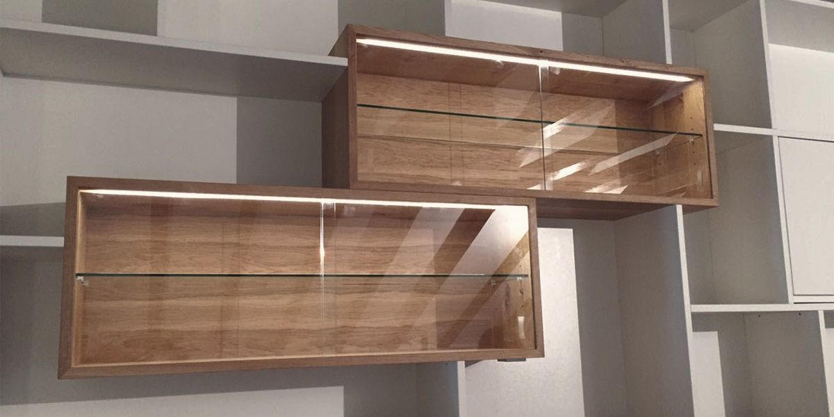 Beleuchtete Eiche-Vitrinen mit Glastüren und Glasböden im Weißlack-Regalsystem eingebaut