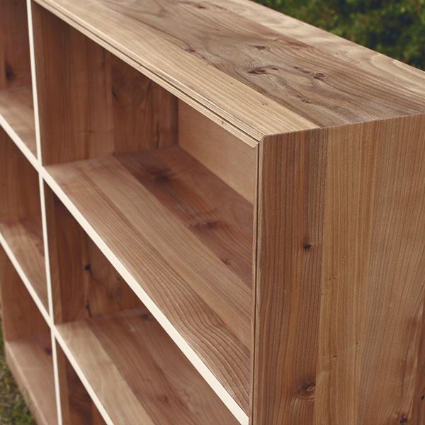 Nahaufnahme der Holzmaserung und Eckverbindung eines Massivholzregals mit sichtbaren Ästen