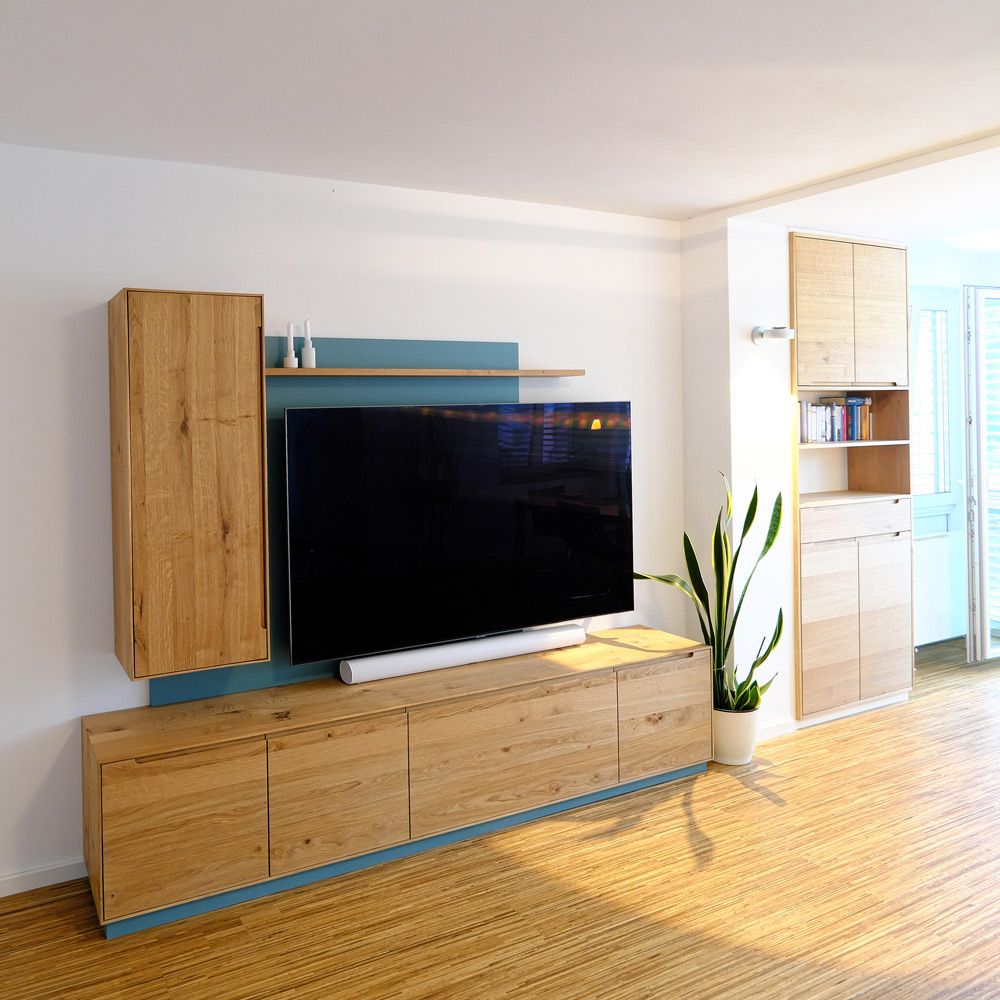 Eichen-Wohnwand mit TV-Sideboard und Hängeschrank, Rückwand in Türkis, im sonnigen Wohnzimmer