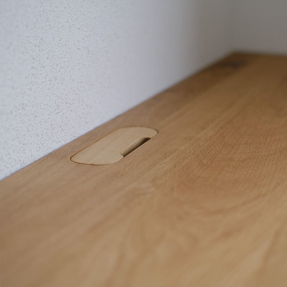 Detailaufnahme eines ausgefrästen Kabelauslasses in massiver Eichenholzplatte