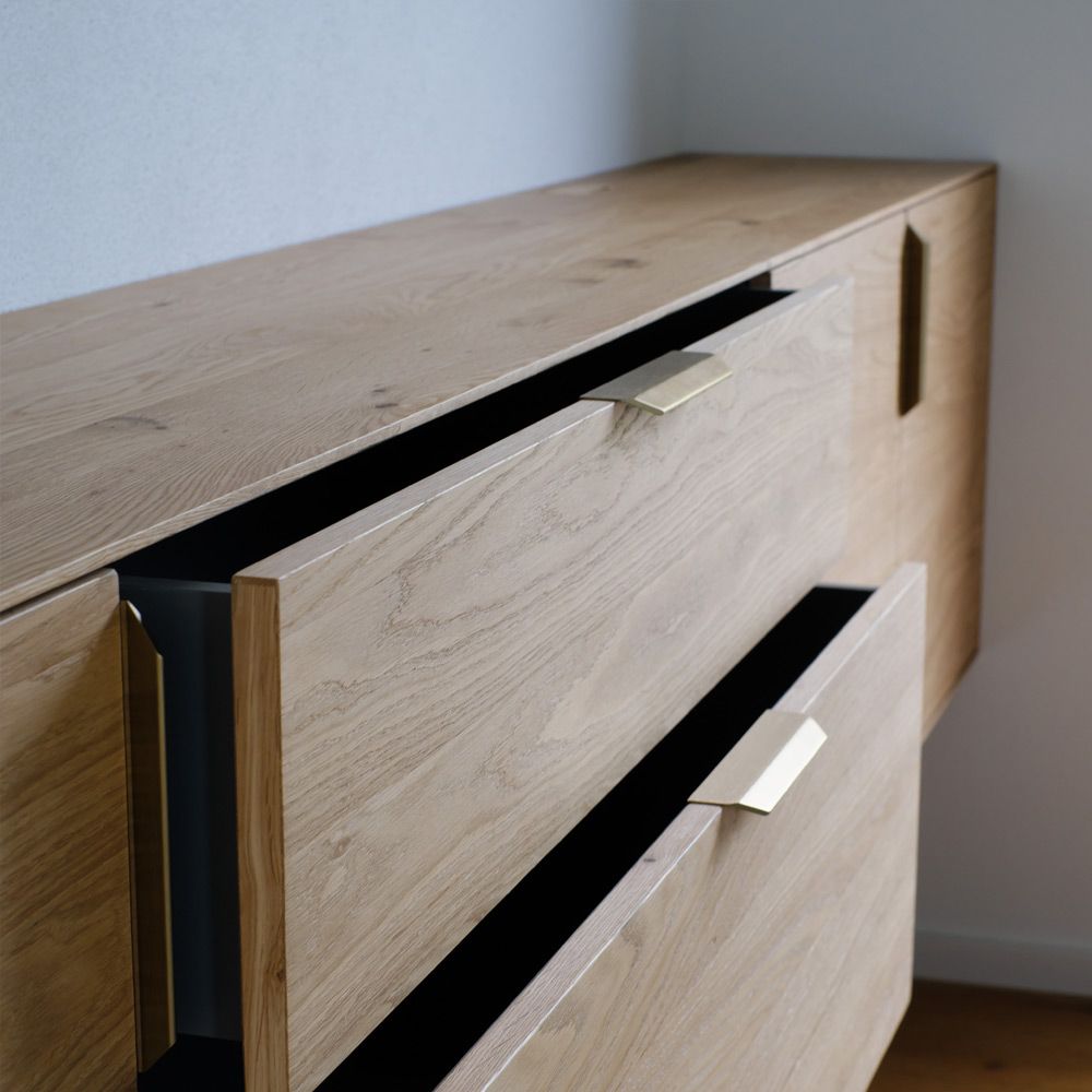 Detailaufnahme einer Eiche-Sideboard-Schublade mit filigranem Messinggriff und feiner Maserung