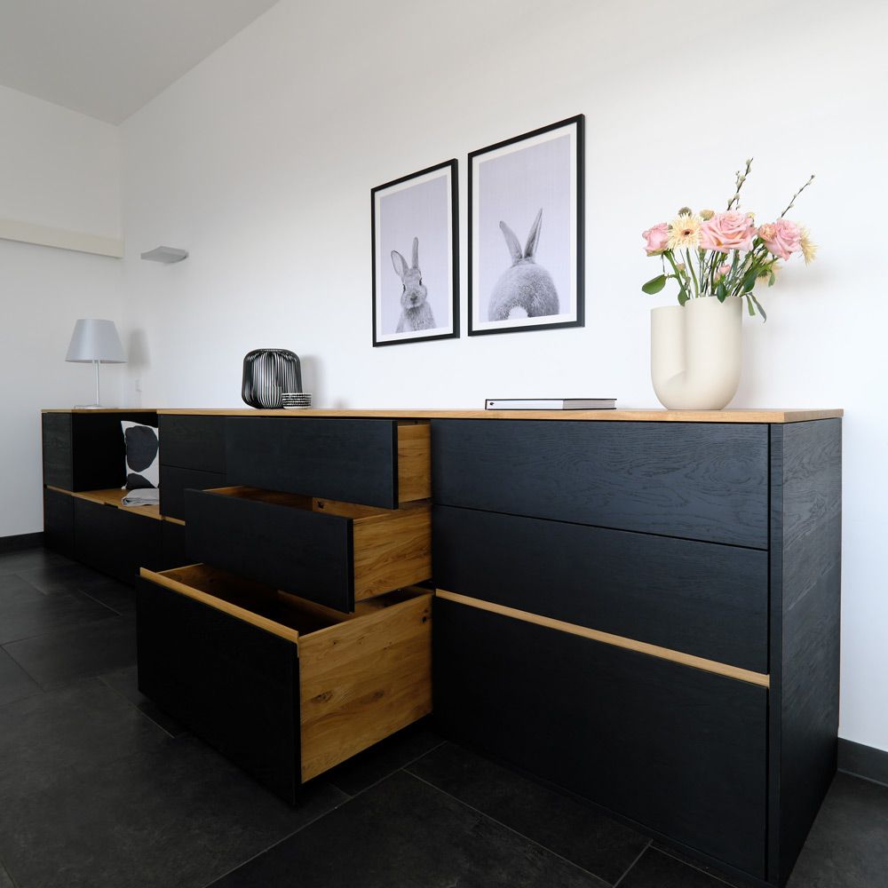 Schwarzes Sideboard mit geöffneten Eichenholz-Schubladen zeigt großzügigen Stauraum