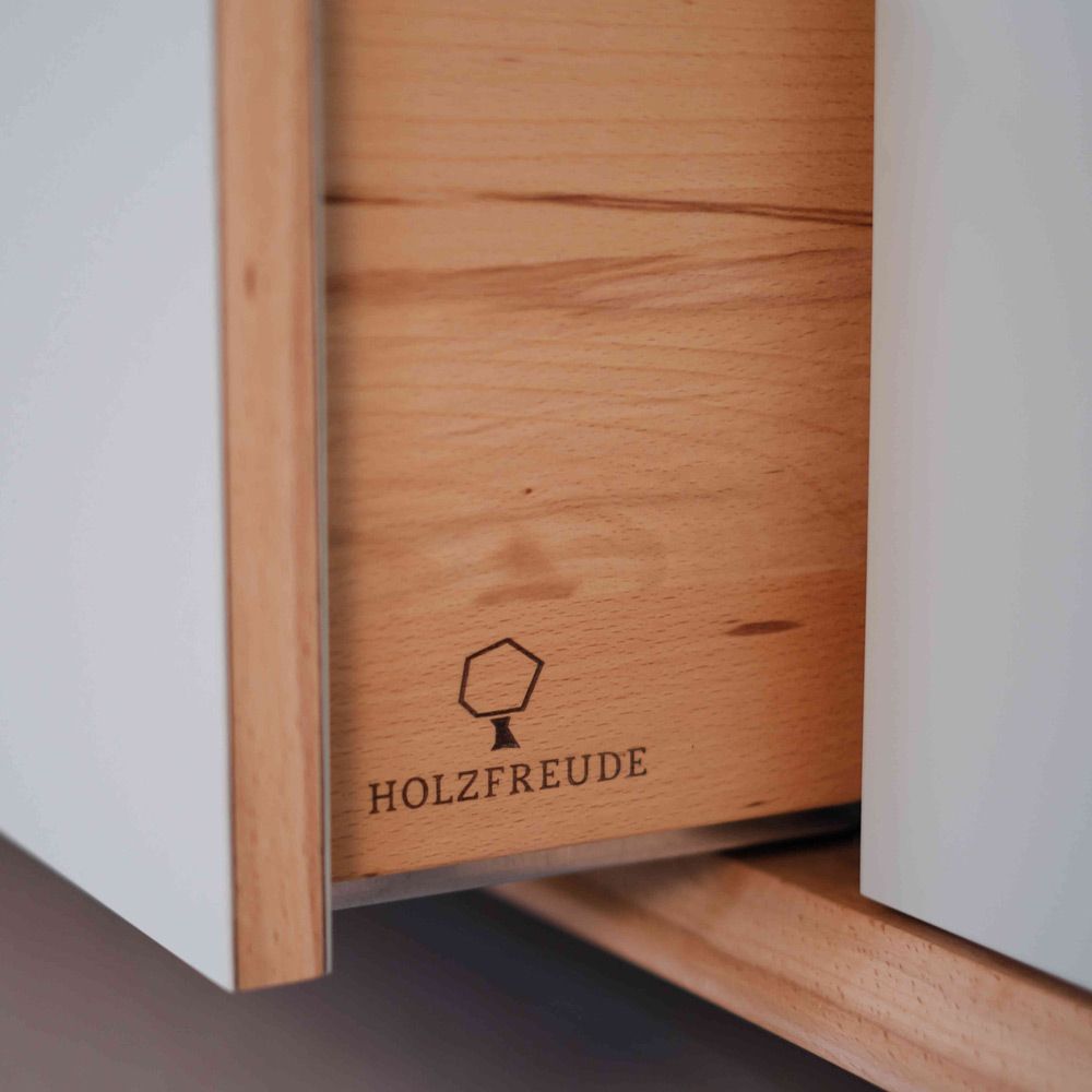 Ausgezogene Kernbuche-Schublade mit eingebrannter Holzfreude-Baumlogo-Gravur