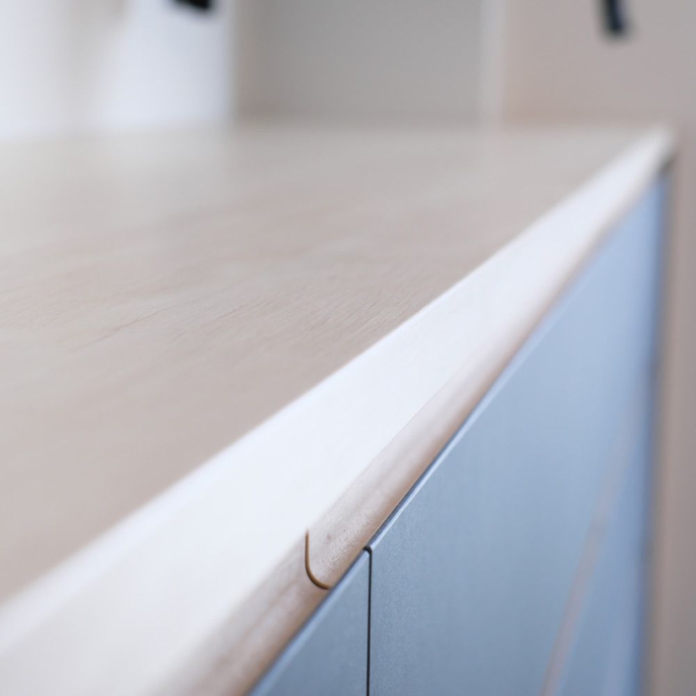 Detailaufnahme abgerundeter Hainbuche-Griffkante an Sideboard mit Linoleumfront