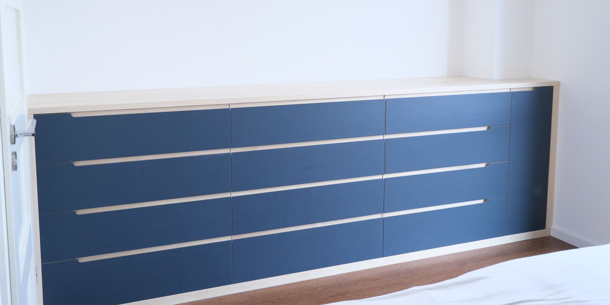 Raumhohes blaues Linoleum-Sideboard mit zahlreichen Schubladen im Schlafzimmer
