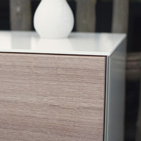 Nahaufnahme der Eckverbindung eines Sideboards mit Holzmaserung und weißer Glasplatte