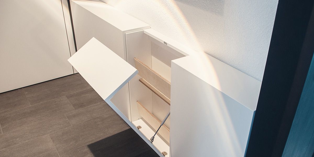 Weißer Schuhschrank mit geöffneter Klappfront und Sperrholz-Einlegeböden, Detailansicht
