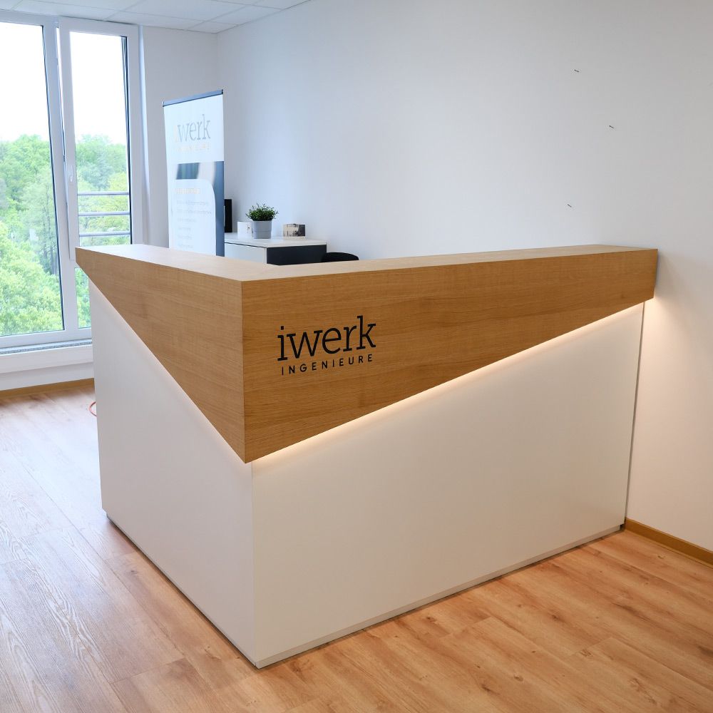 Empfangstheke aus Eiche und weißem Lack mit LED-Lichtkante und Firmenlogo im Büro