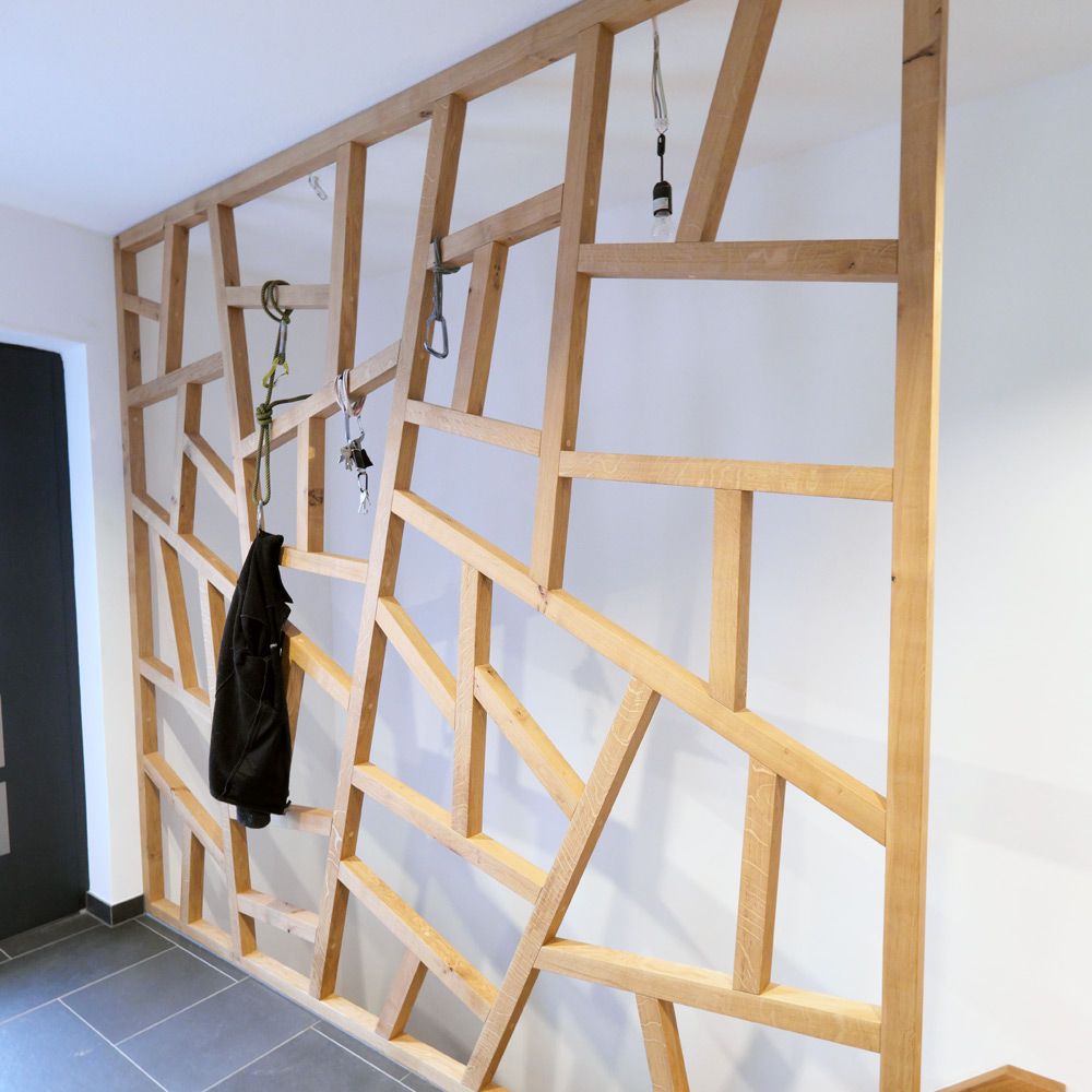 Raumhohe Garderobenwand aus Eiche mit geometrischem Stabmuster als individuelle Flurgestaltung