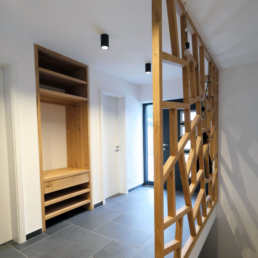 Eingangsflur mit offenem Eichen-Garderobenschrank und geometrischem Holz-Raumteiler