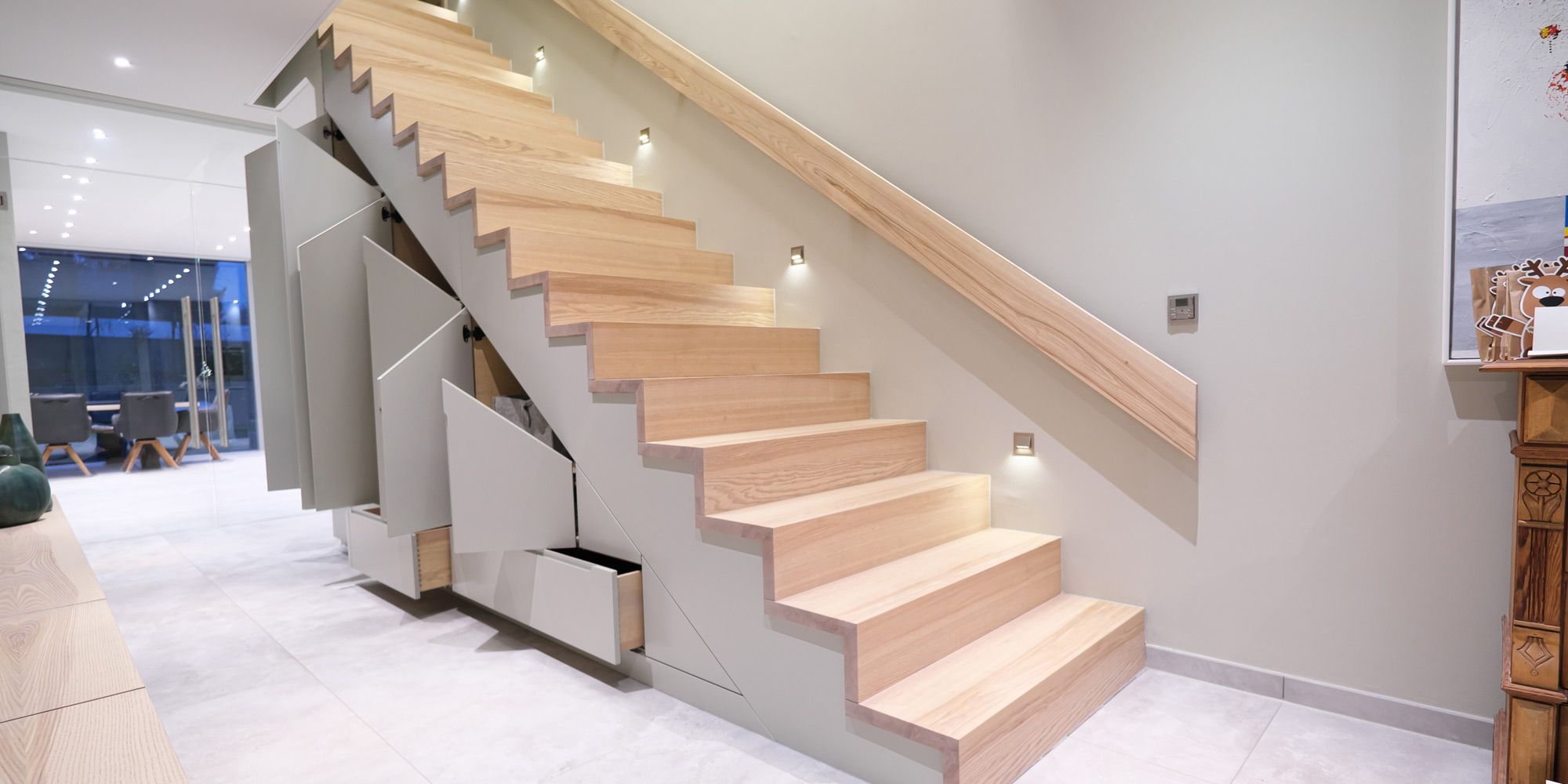 Treppenschrank mit geöffneten Türen und Schubladen zeigt cleveren Stauraum unter der Treppe