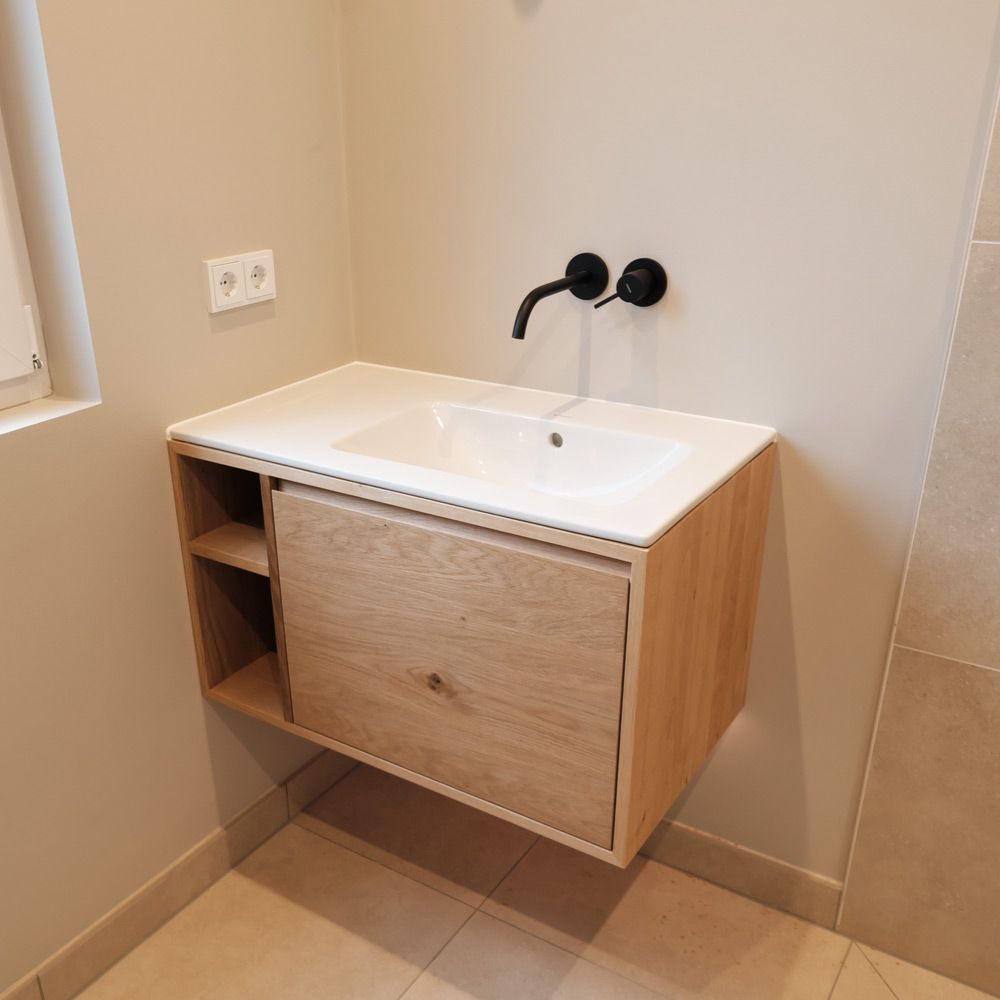 Schwebender Eiche-Waschtisch im Gäste-WC mit offenem Fach und schwarzer Wandarmatur