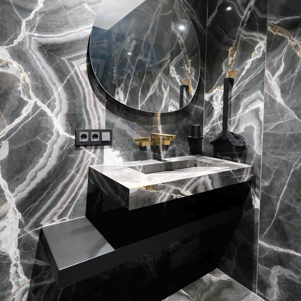 Gäste-WC komplett in schwarzem Marmor mit Waschtisch, goldener Armatur und Rundspiegel