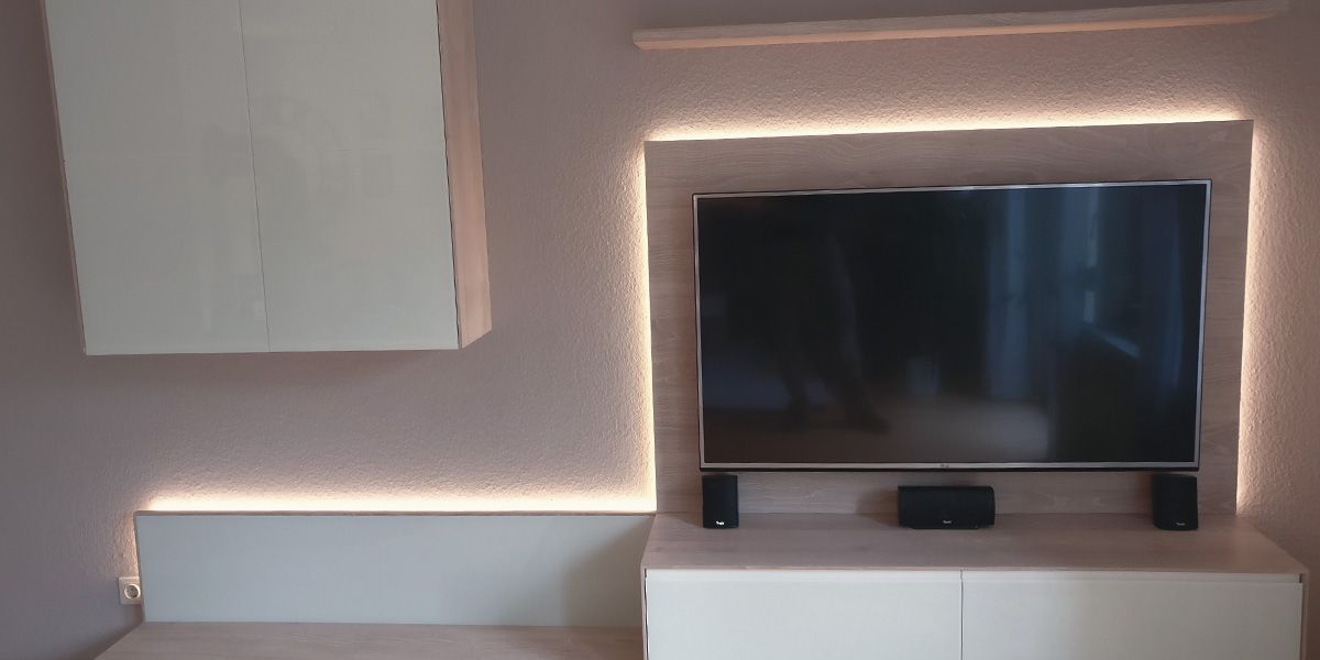 TV-Wohnwand aus hellem Holz mit LED-Hinterleuchtung und weißen Hochglanzfronten