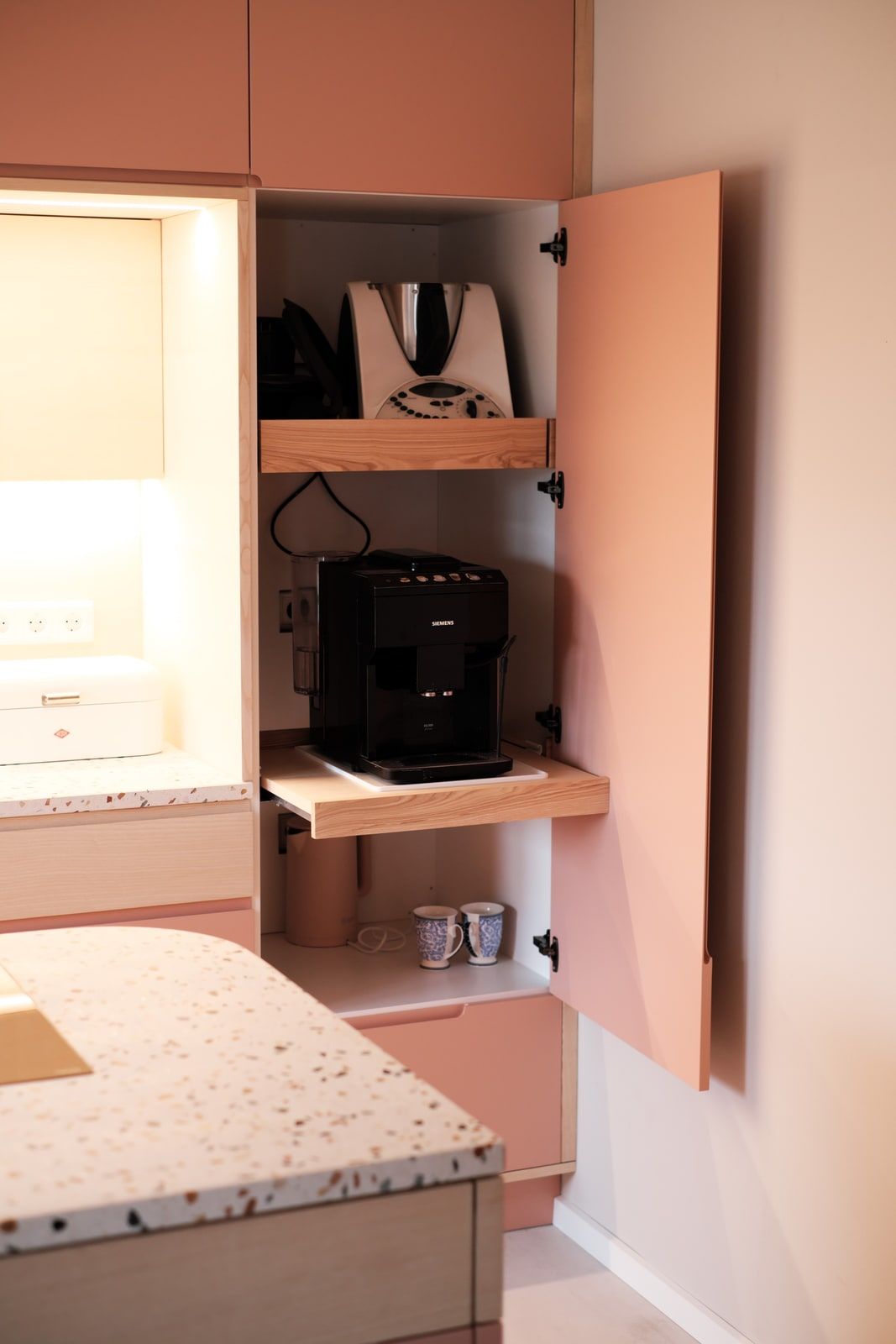 Rosé Küchenschrank mit ausklappbarem Kaffeemaschinen-Fach und Terrazzo-Arbeitsplatte