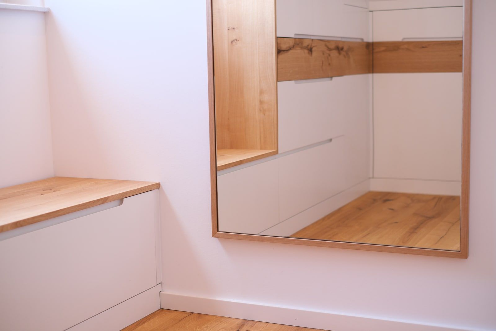 Ankleide mit weißer Maßkommode, Eichendeckplatte und großem Wandspiegel im Eichenrahmen