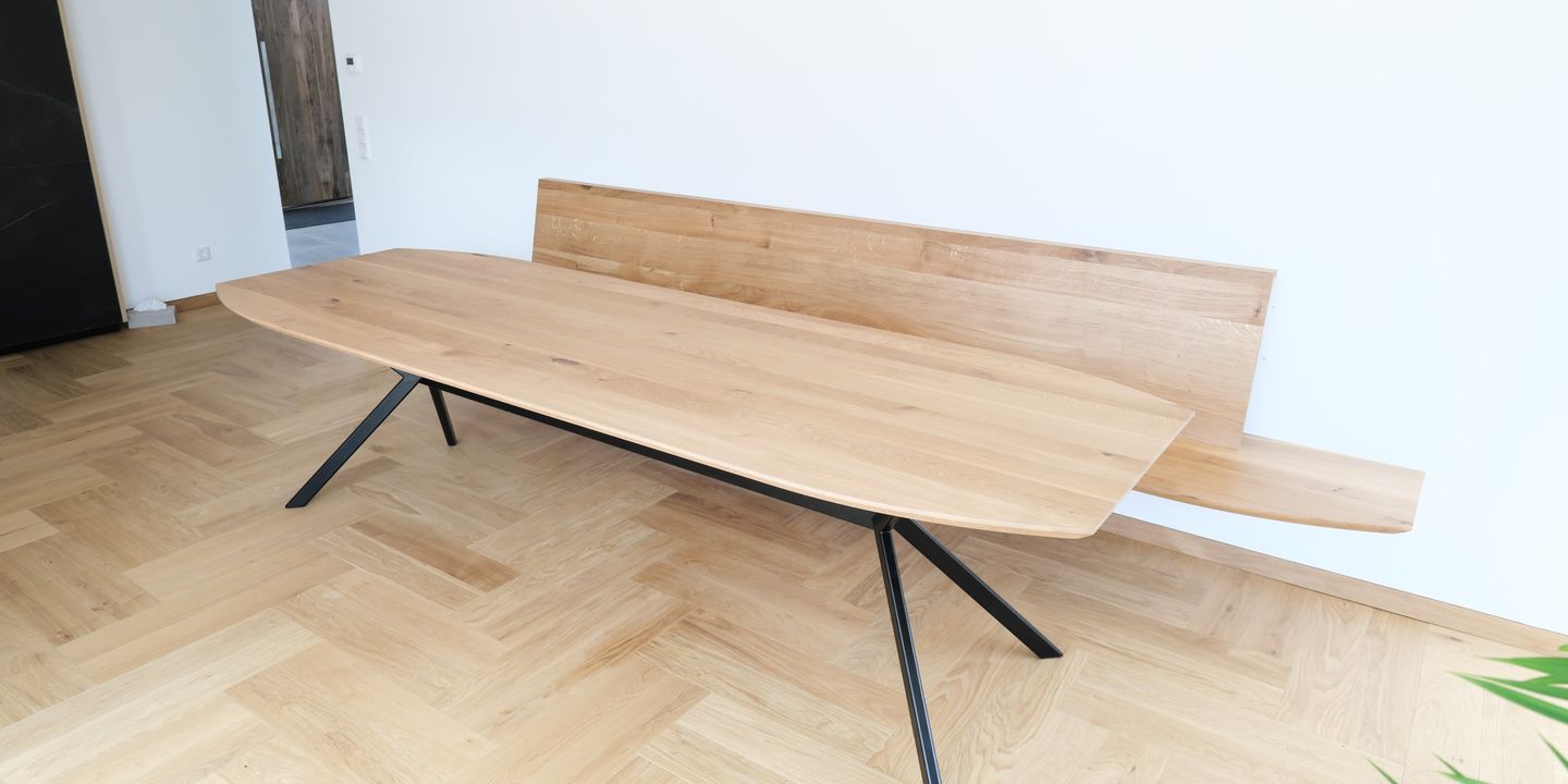 Esstisch aus Eiche massiv mit schwarzem Gestell vor weißer Wand und Fischgrätparkett