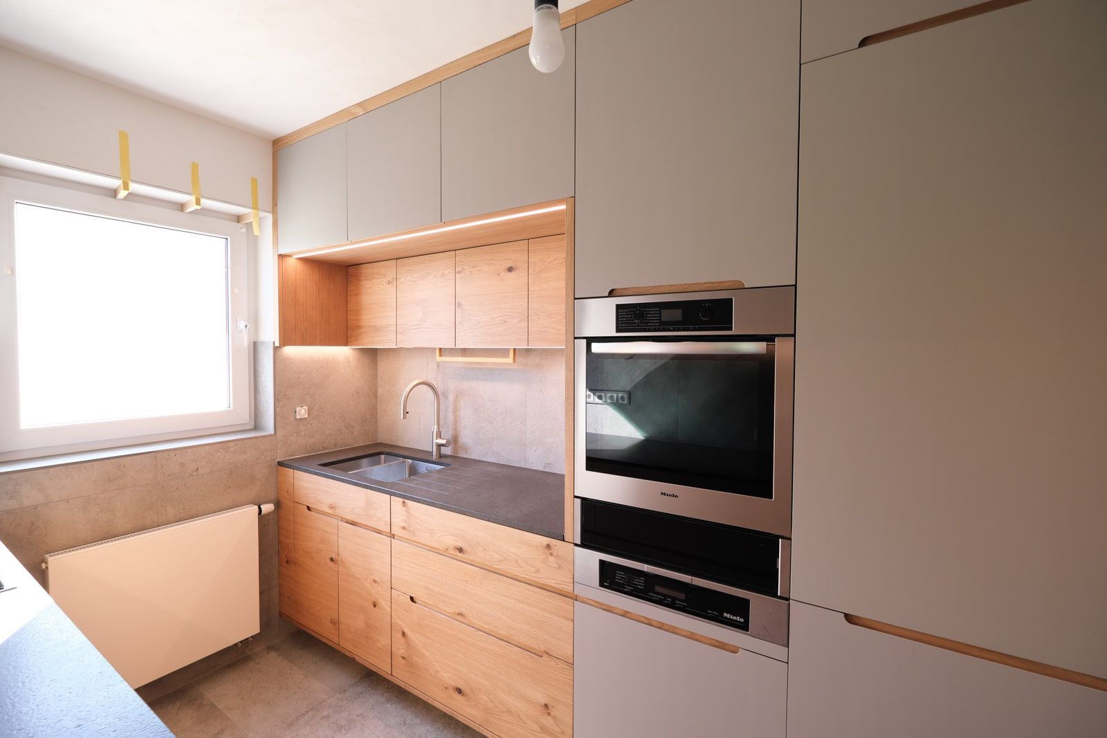 Küchenzeile aus Eiche mit Fenster, Edelstahl-Spüle und grauen Hochschränken