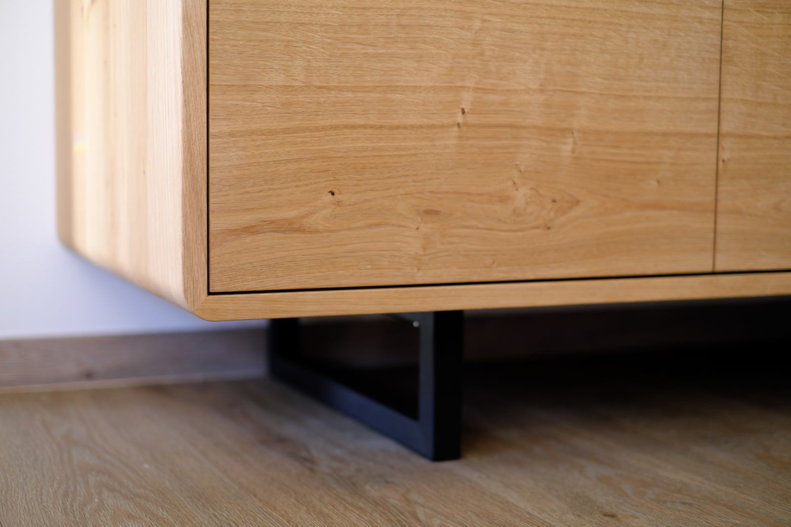 Detailansicht des Metallfußes am Eichensideboard mit Frontplattenfuge