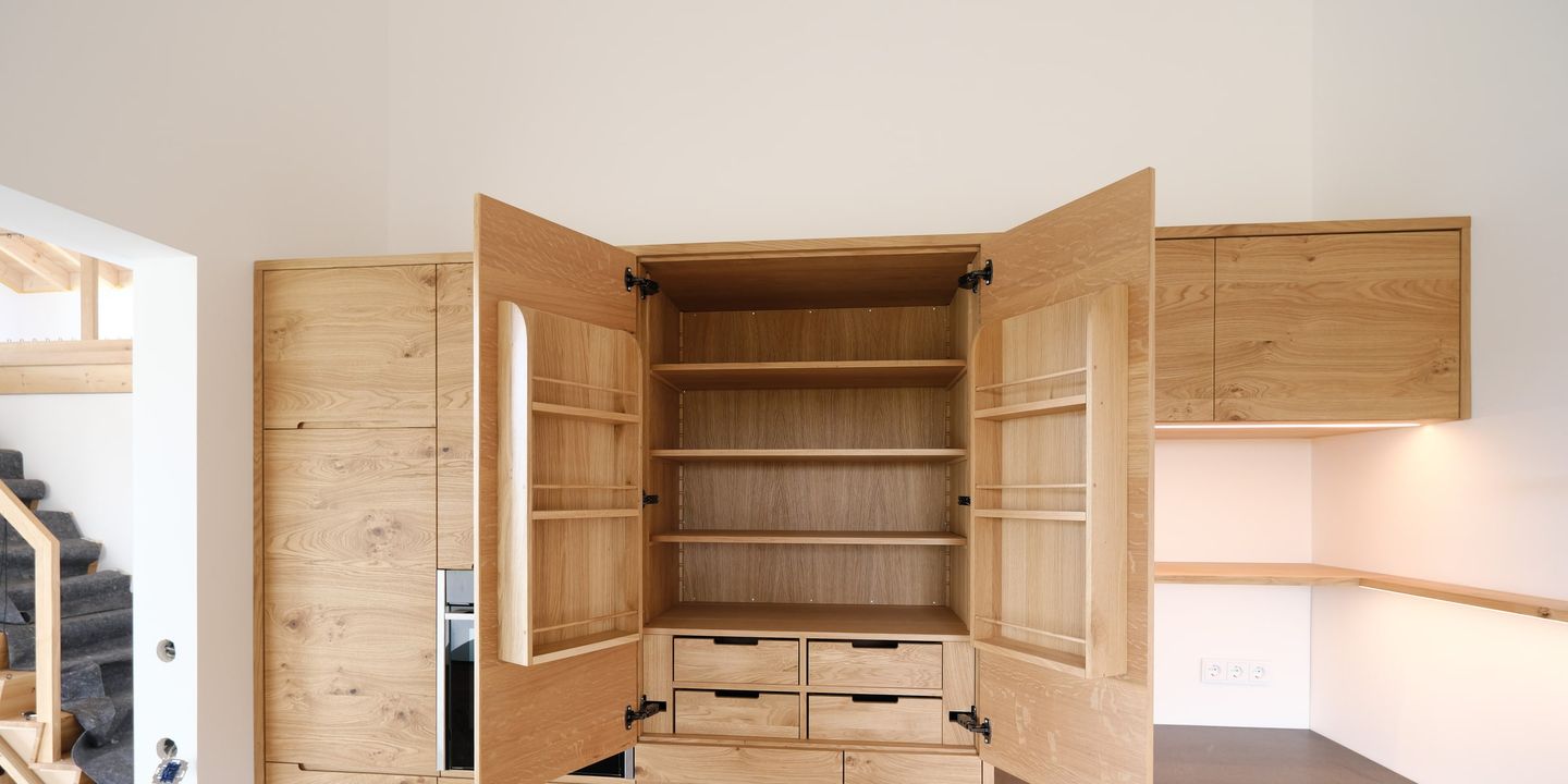 Geöffneter Massivholzschrank aus Eiche mit Regalböden, Türfächern und Schubladen
