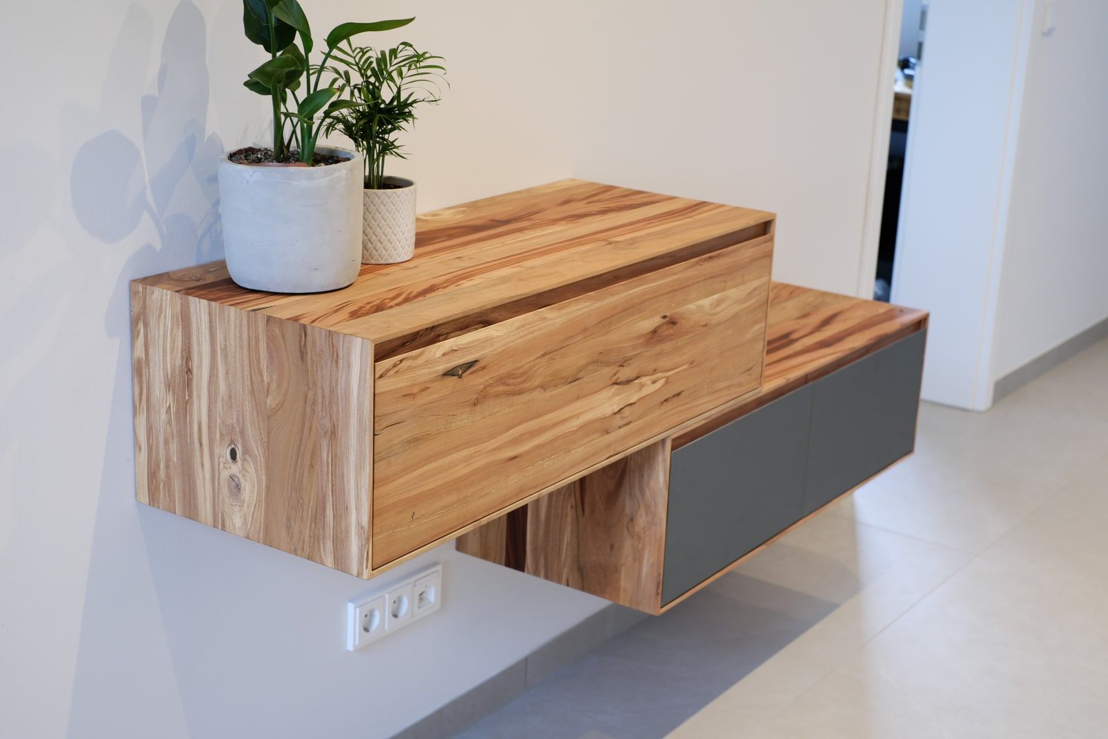 Schwebendes Sideboard aus Massivholz mit anthrazitfarbenen Fronten im modernen Flur