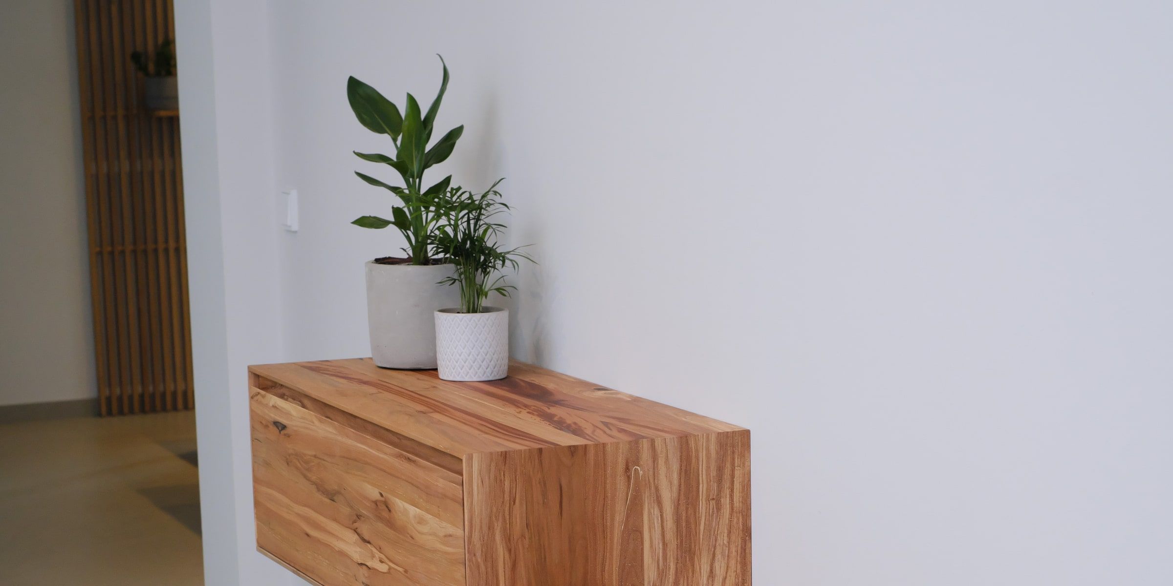 Schwebendes Sideboard aus Nussbaum mit grauer Front im Flur, zweistufig an der Wand montiert