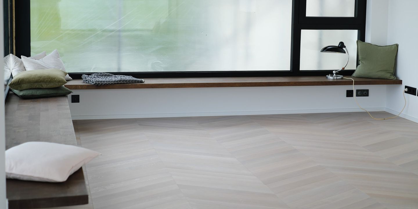 Holz-Fensterbank mit Kissen entlang des großen Panoramafensters im Erker