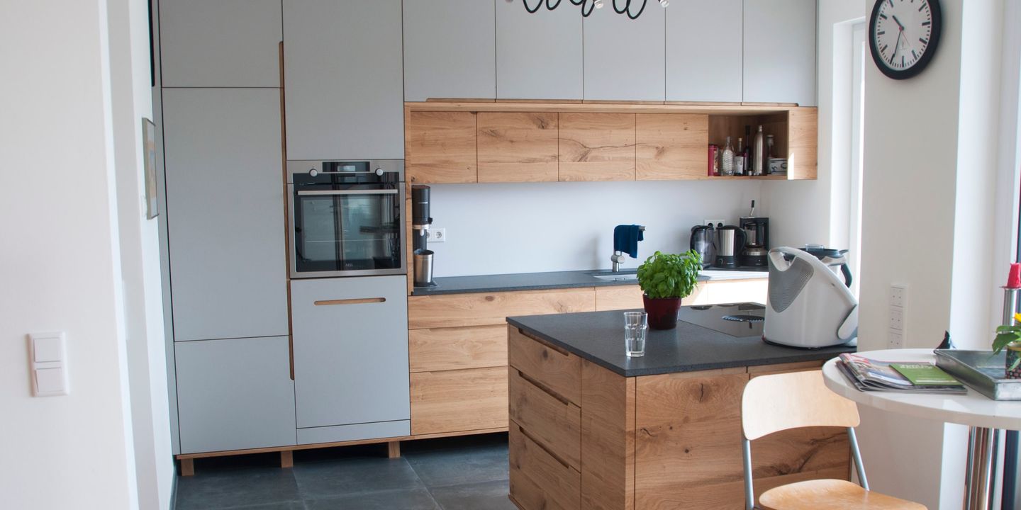 Moderne Küche mit Eiche-Fronten, grauen Hochschränken und freistehender Kochinsel