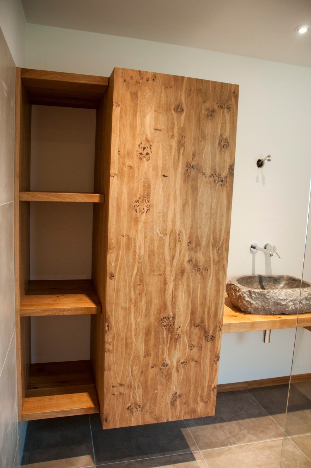 Nahaufnahme astreicher Eiche mit offenem Regalfach im Badezimmerschrank