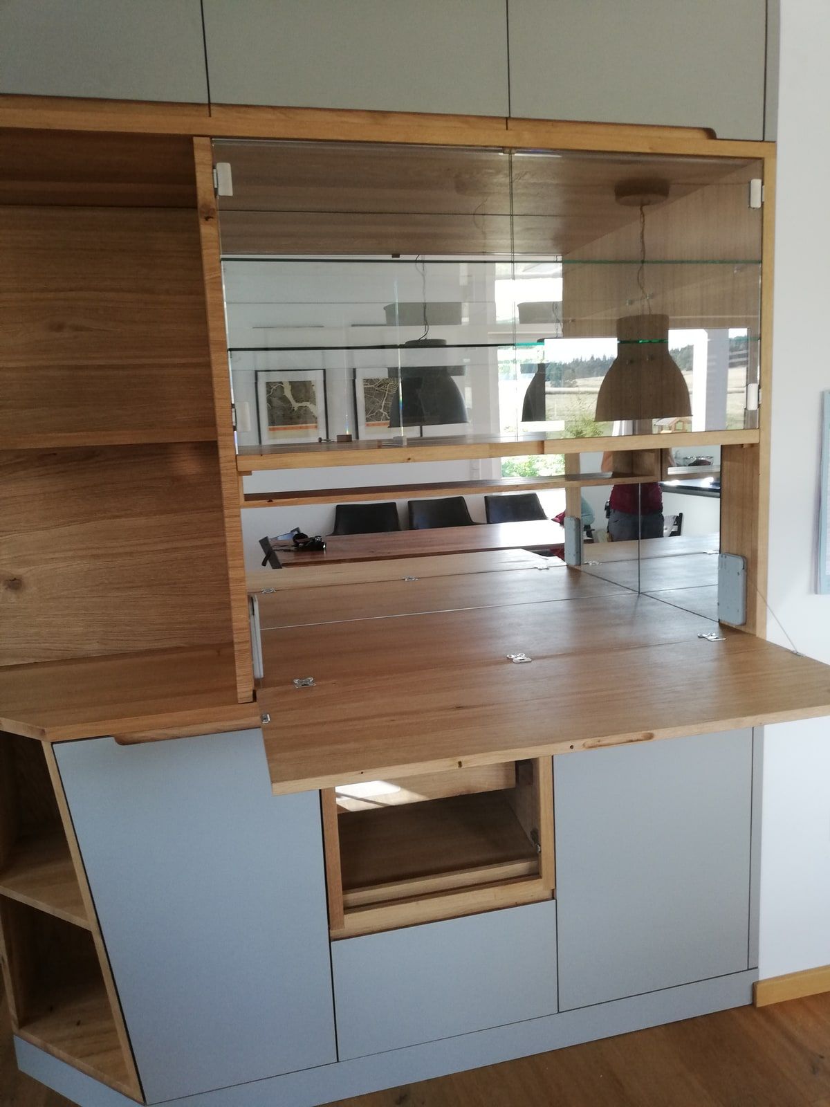 Wohnwand mit Sekretär, Klappfläche und Spiegelrückwand aus Eiche massiv