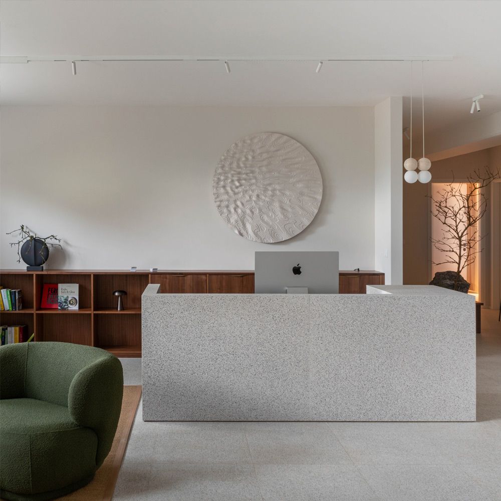 Empfangstheke aus Caesarstone Quarzkomposit mit Nussbaum-Regal in minimalistischer Praxis